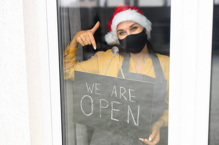 Young woman holding open sign in cafeの写真素材