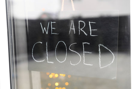 View through the glass door at closed signの写真素材