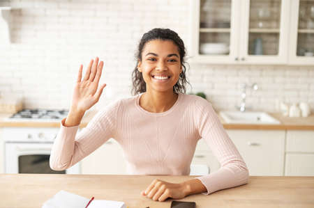 Front view of friendly adorable African American female freelancer teenage girl with Afro hairstyle...