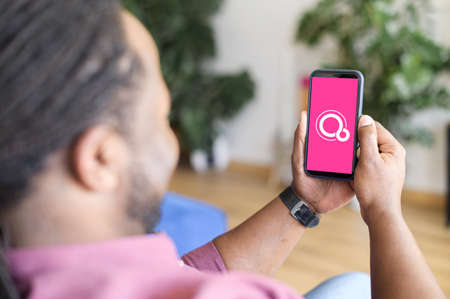 Kyiv, Ukraine - April 28, 2021: Smartphone in male hands with Google Fuchsia OS on the screenのeditorial素材