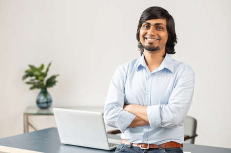 Ambitious and high skilled indian male entrepreneur stands in confident pose in modern office,...
