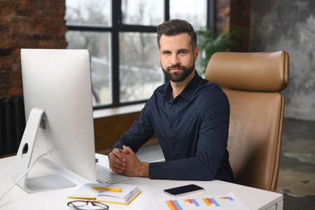 Confident male worker looking at the camera with calm emotions while sitting on the break. Guy...