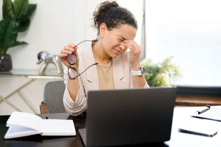 Female employee massaging back of the neck, feels muscle strain. Depressed md-age woman feels tired...