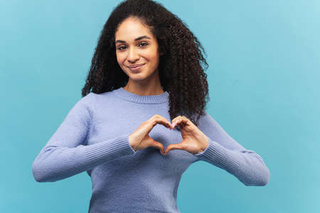 Nice young beautiful African American woman with afro hairstyle with curly hair wearing violet...