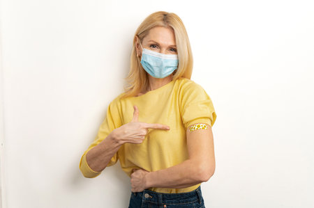 Healthcare and medical. Mature woman wearing protective mask protect herself with vaccine against...