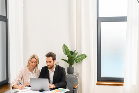 Waist up portrait view of the business man and woman using laptop for work from office. Confident...