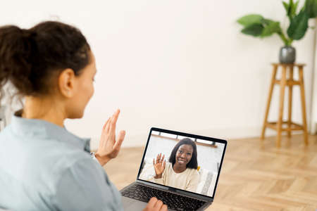 Close-up of woman with long hair using app for distance video communication with coworker, friend,...