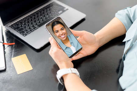 Video communication via smartphone. Woman is using phone app for video call, online meeting. She...