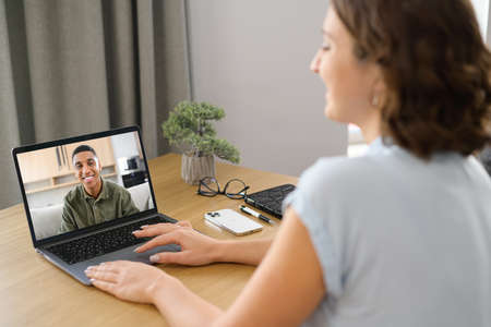 Video call, video meeting with colleague, coworker. Young woman watching on PC display with a...