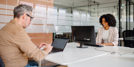 Business professionals collaborating on work in a contemporary office space, engaging in strategic planning and corporate development. A productive environment fostering growth and efficiency.の写真素材