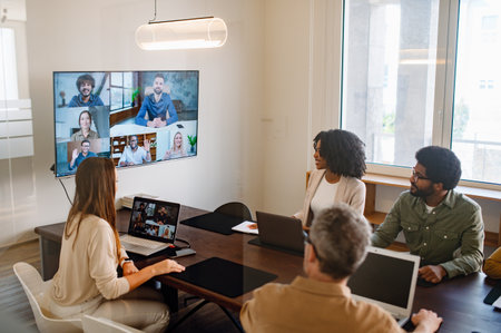 A professional business team participating in a remote video meeting. A modern workspace fostering digital communication, teamwork, and productivity.の写真素材