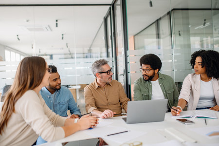 A business team engaging in an insightful strategy meeting in a contemporary office setting. Effective communication fosters growth, leadership, and success in corporate environmentsの写真素材