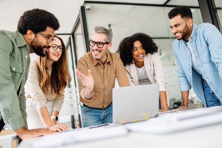 Confident business team working on a strategy at a desk, analyzing financial reports and discussing company growth. A diverse team in a corporate setting collaborating for success and innovatioの写真素材