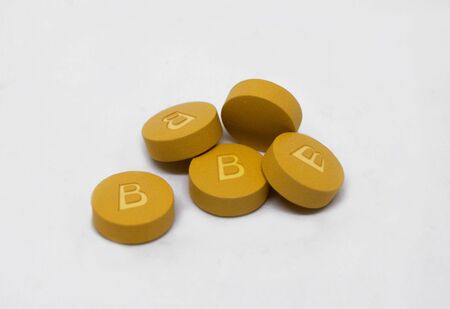 Vitamin B pills to create energy and red blood cells with text isolated on white backgroundの写真素材