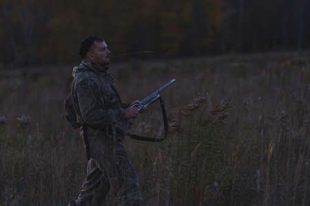 Male hunter in camouflage clothes ready to hunt with hunting rifle