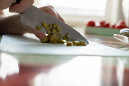 Girl cuts ingredients for olive salad.の写真素材