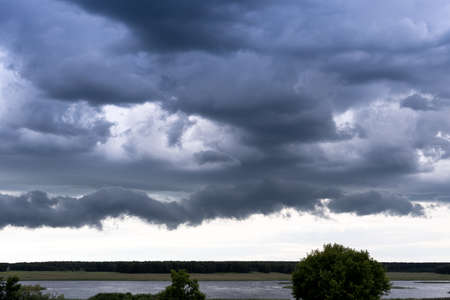 Storm clouds over the lake. Rainy season.の写真素材
