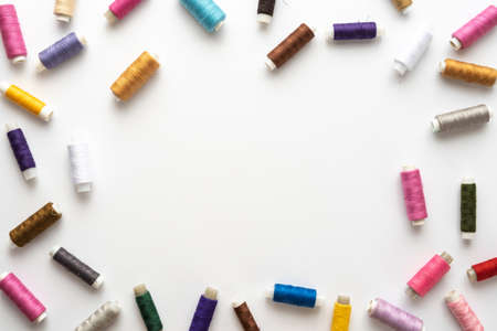 Flat lay composition with sewing thread on white background. Space for textの写真素材