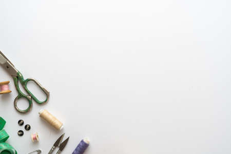 Flat lay composition with scissors and other sewing accessories on white background. Space for textの写真素材