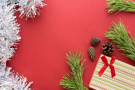 Christmas composition. Christmas decoration white tinsel on a red background. Flat lay, top view, space for textの写真素材