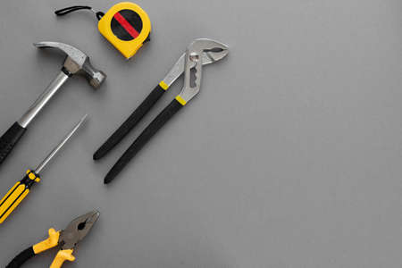 Flat lay composition with construction and home repair tools tools on gray background, space for textの写真素材