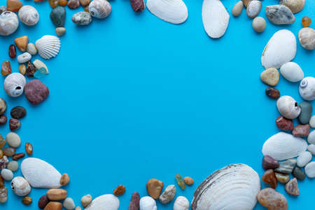 Flat lay composition sea pebbles and seashells on a blue background. space for textの写真素材