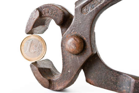 Euro coin in rusty pliers as symbol for the fincancial problems of that country のeditorial素材