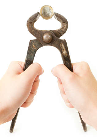 Euro coin in rusty pliers as symbol for the fincancial problems of that country のeditorial素材