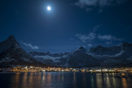 Night sky over the mountains sea and villageの写真素材