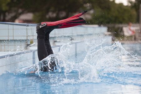 Scuba diver jumping into swimming poolの写真素材