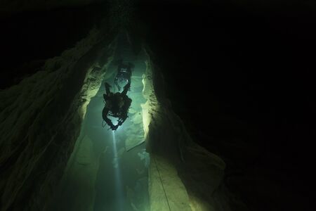 Scuba Diver Silhouette in a Dark Caveの写真素材