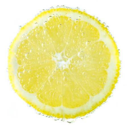 Fresh lemon in soda water covered with bubbles  isolated on white backgroundの写真素材