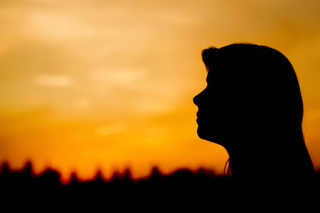 Woman silhouette in summer, nice sunset in background.の写真素材