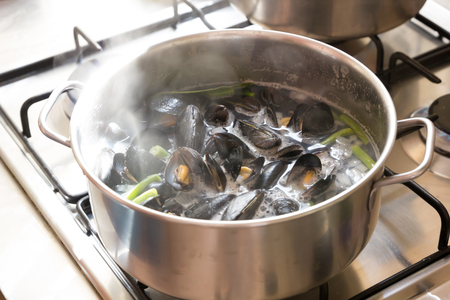 Boiling sea mussels in wine in a potの写真素材