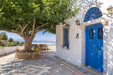 Typical greek house nwxt to the treeの写真素材