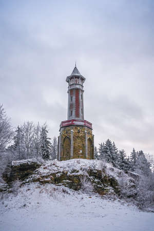 Lookout tower Stepanka on the border of Krkonose and Jizera Mountains. Winter overcast day, sky with clouds, trees covered with snow.の写真素材