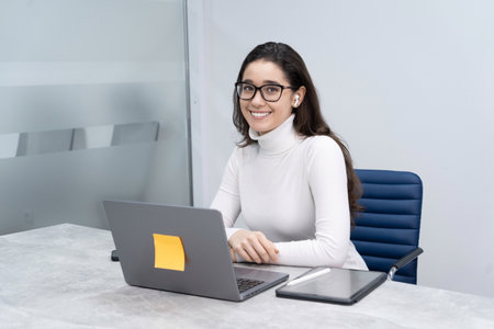 Portrait of young business woman laptop and digital tablet in modern officeの写真素材