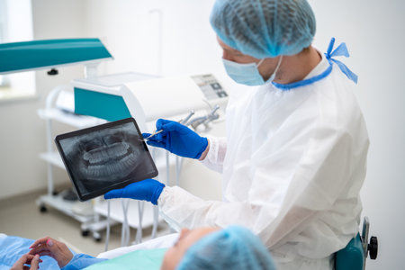 Dentist showing dental x ray to patient in clinicの写真素材