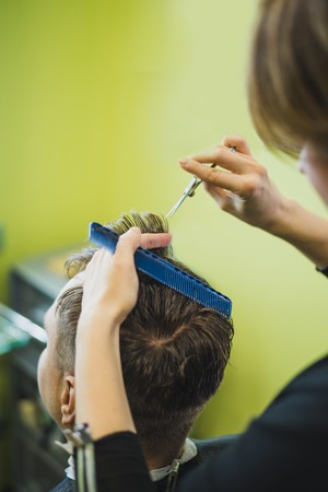 Professional barber styling hair of his client, hand of barberの写真素材