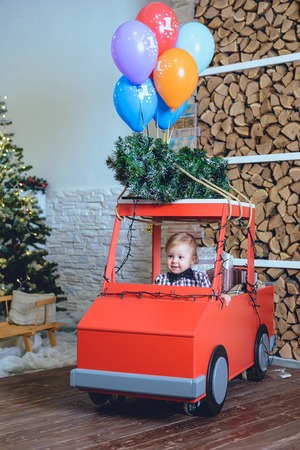 little kid near christmas tree playing and smilingの写真素材