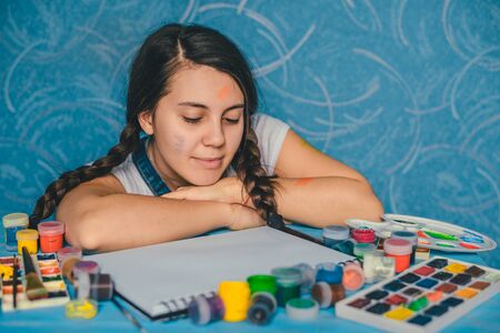 Attractive woman searching for muse with paintsの写真素材