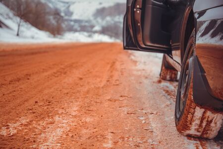 lonely car road in snow red because of ore