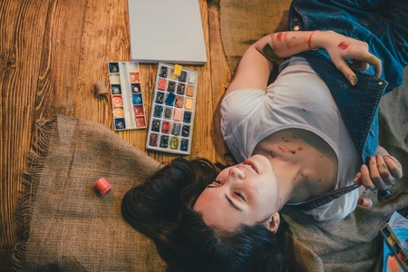 Woman lying on the floor paint all over her