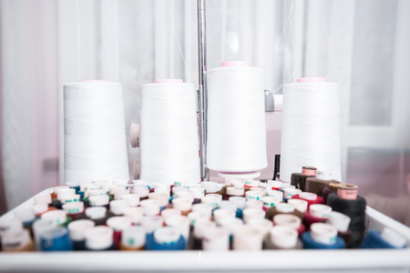 beautiful woman seamstress sew on the sewing machine clothes. sewing workshopの写真素材