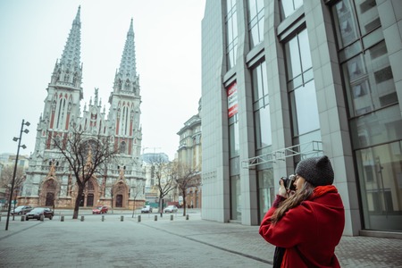 young woman take a picture of old church