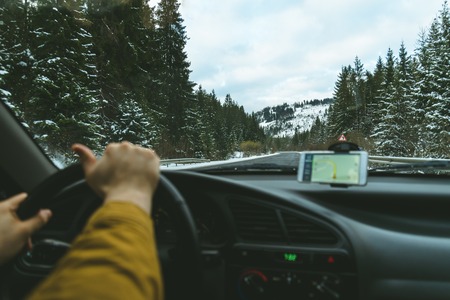 Drivers hands on a steering wheel and blurred roadの写真素材