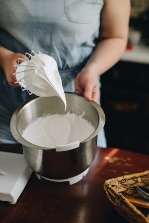 Young woman baking a cake using a mixerの写真素材