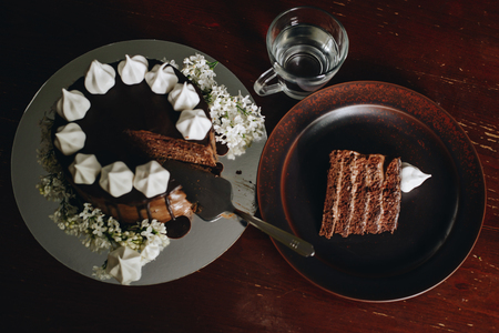 chocolate cake on a plate with glass of water