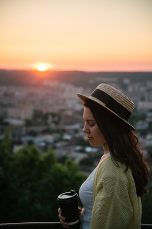 woman sit on the hill and lookin on sunsetの写真素材