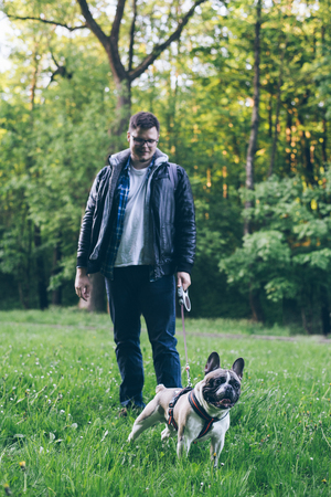 man walk with french bulldog in city parkの写真素材